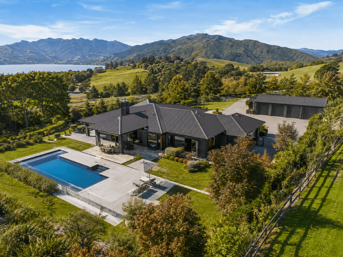 Aerial view of a lifestyle home with a pool and mountain outlook